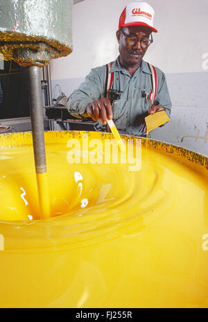 African American uomo vernice di miscelazione in fabbrica industriale Foto Stock