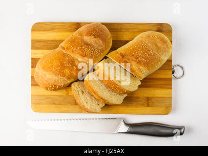 Tutto il frumento due tipi di pane con un coltello su un tagliere Foto Stock