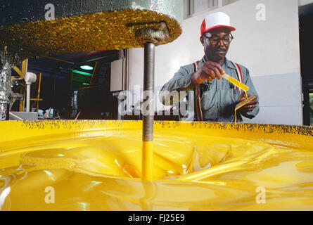 African American uomo vernice di miscelazione in fabbrica industriale Foto Stock