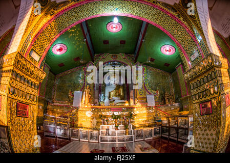 MANDALAY, Myanmar - la Pagoda Sutaungpyei si trova in cima alla collina Mandalay, offrendo vedute panoramiche della città sottostante. Lo stupa dorato della pagoda brilla alla luce del sole, circondato da padiglioni e santuari ornati. Visitatori e pellegrini esplorano il complesso del tempio, alcuni si fermano per pregare o fare offerte presso le varie statue di Buddha. Foto Stock