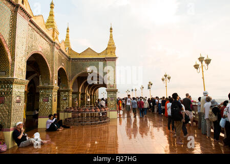 MANDALAY, Myanmar - la Pagoda Sutaungpyei si trova in cima alla collina Mandalay, offrendo vedute panoramiche della città sottostante. Lo stupa dorato della pagoda brilla alla luce del sole, circondato da padiglioni e santuari ornati. Visitatori e pellegrini esplorano il complesso del tempio, alcuni si fermano per pregare o fare offerte presso le varie statue di Buddha. Foto Stock