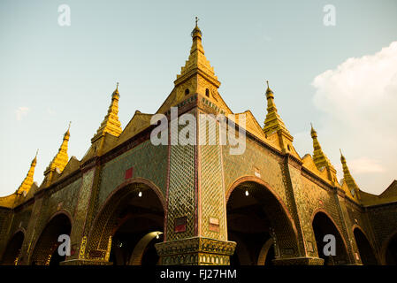 MANDALAY, Myanmar - la Pagoda Sutaungpyei si trova in cima alla collina Mandalay, offrendo vedute panoramiche della città sottostante. Lo stupa dorato della pagoda brilla alla luce del sole, circondato da padiglioni e santuari ornati. Visitatori e pellegrini esplorano il complesso del tempio, alcuni si fermano per pregare o fare offerte presso le varie statue di Buddha. Foto Stock