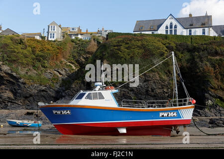 Barca a bassa marea nel porto di Port Isaac, Cornwall, Regno Unito. Foto Stock