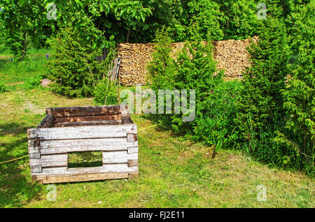 Molla. Old Log Cabin - base di legno per il forno. Forno all'interno di casa in legno realizzato dal rosso mattone di creta. Foto Stock