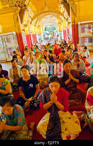 Pregare birmano al molto venerata MAHAMUNI BUDDHI all'interno della MAHAMUNI PAYA costruito da Re Bodwpaya nel 1784 - Mandalay, MYANMAR Foto Stock