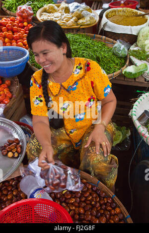 Arrosto di castagne d'acqua, pomodori e peperoncini per la vendita al mercato centrale in BAGO - Myanmar Foto Stock