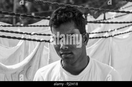 Un giovane uomo nel Mahalaxmi Dhobi Ghat, il più grande del mondo colonia washermen, nel centro di Mumbai, India Foto Stock