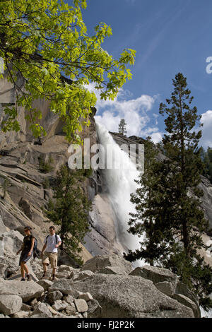 Gli escursionisti di seguito Nevada Falls che scende 594 piedi come teste nella Yosemite Valley - Yosemite National Park, California Foto Stock