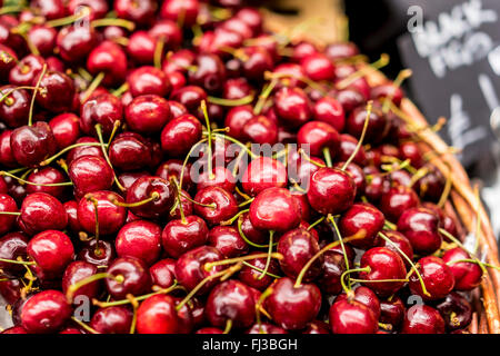Close up di un paniere di prodotti freschi ciliegie mature per la vendita su un mercato in stallo Foto Stock