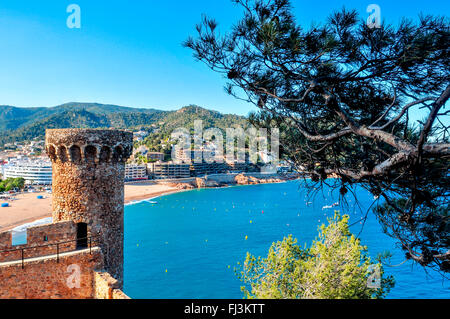 Una vista delle mura e torri della Vila Vella, la vecchia città di Tossa de Mar, Spagna Con Platja Gran beach in backgro Foto Stock