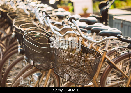 Riga della città le biciclette parcheggiate affitto biciclette sul marciapiede. Bike bicicletta Parcheggio in strada Foto Stock