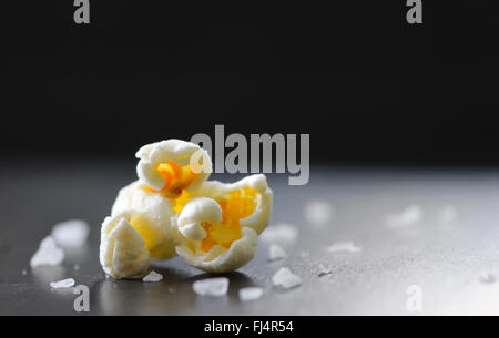 Unico di popcorn e sale isolato su sfondo nero Foto Stock