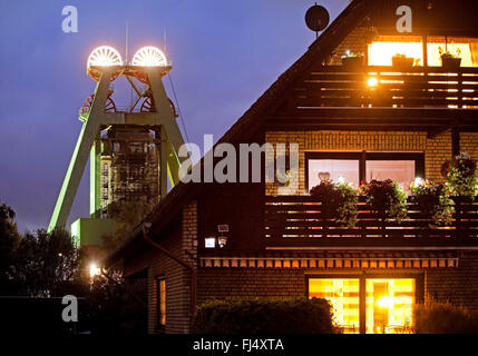 Casa residenziale e illuminato headframe della miniera di carbone di Haus Aden di sera, in Germania, in Renania settentrionale-Vestfalia, la zona della Ruhr, Bergkamen Foto Stock