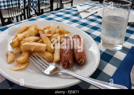 Salsicce e chip su un piatto in un ristorante. Foto Stock