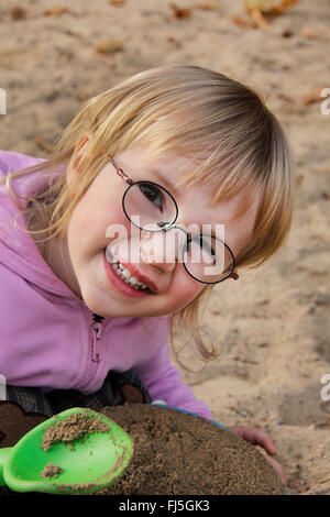 Bambina giocando nella sabbia, ritratto di un bambino Foto Stock