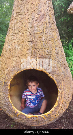 Little Boy in seduta appeso un nido di uccelli modello Foto Stock