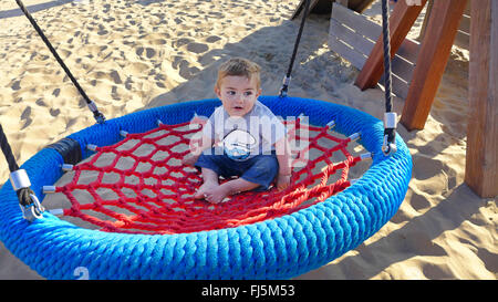 Piccolo Ragazzo seduto in un nido swing, Paesi Bassi Foto Stock