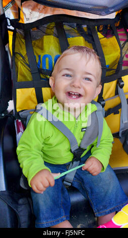 Felice piccolo ragazzo seduto in un buggy e ridere, Paesi Bassi Foto Stock