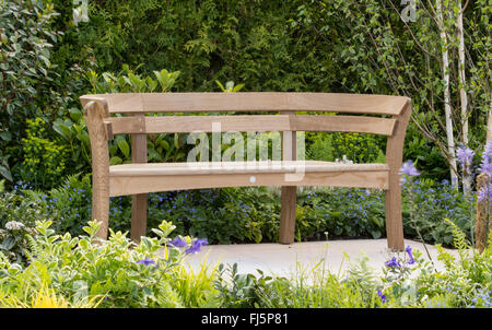 Piccolo giardino con area salotto, panca da giardino in legno di quercia realizzata da Burvill su un patio pavimentato in pietra al RHS Malvern Spring Show UK Foto Stock