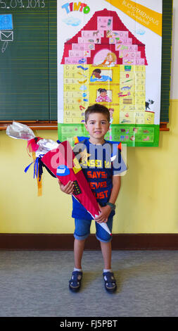 Primo-grader con permanente First-Day-scuola-corno di fronte a una lavagna, Germania Foto Stock