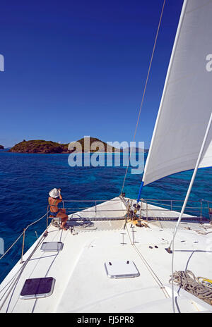 Donna di scattare le foto alla parte anteriore del catamarano barca a vela a Tobago Cays, Saint Vincent e Grenadine Foto Stock