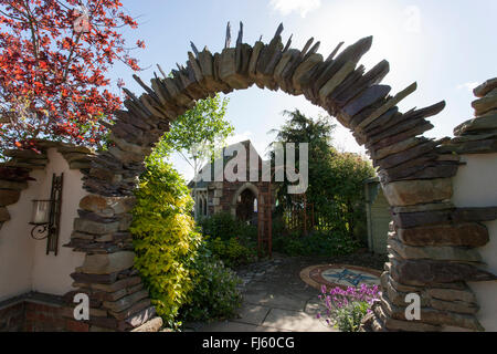 Moongate realizzata in pietra, pavimentazione in pietra e mattoni struttura edificio, alchimia giardini mostra permanente giardino Malvern tre counti Foto Stock