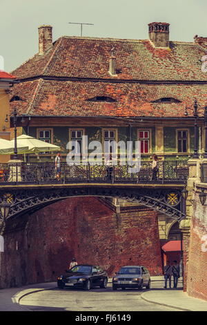 SIBIU, Romania - 06 Maggio 2015: persone non identificate visitare il Ponte di menzogne che collega la piccola piazza con Huet Square in S Foto Stock