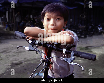 Ragazzo poggiando sulla sua bicicletta, Vietnam, Hoi An Foto Stock