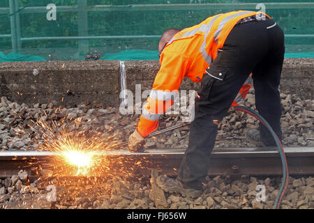 Operaio ferroviario il taglio i binari della ferrovia con un cannello, Germania Foto Stock