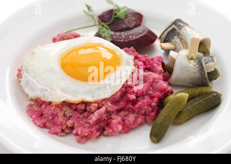 Labskaus con uovo fritto, cetriolino sottaceto, barbabietole e rollmops Foto Stock