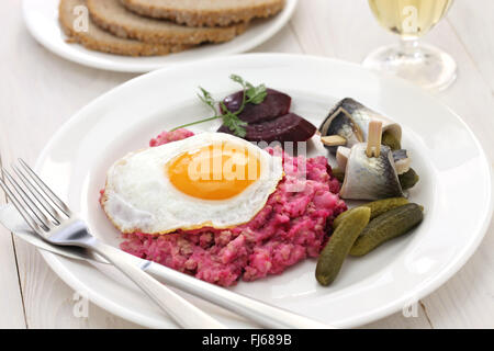 Labskaus con uovo fritto, cetriolino sottaceto, barbabietole e rollmops Foto Stock