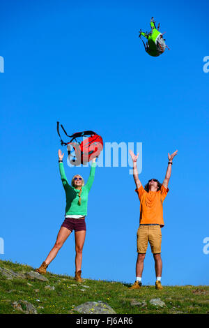 Due giovani lanci di gioia i loro zaini , Francia, Savoie Foto Stock
