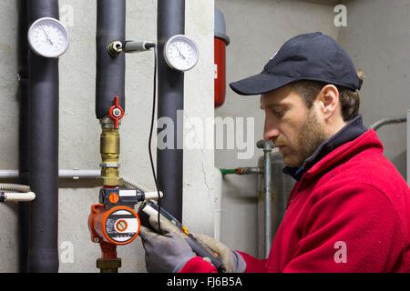 Plumber lavorando misura la temperatura in una potenza termica Foto Stock