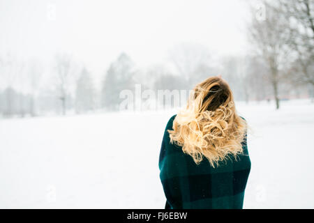 Donna bionda gettando i suoi capelli, natura invernale, vista posteriore Foto Stock