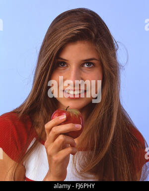 Giovane donna azienda apple, London, England, Regno Unito Foto Stock