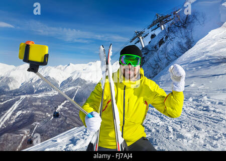 Felice sciatore uomo prendendo selfie sulla montagna Foto Stock