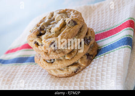 Pila di cioccolato artigianale chip cookie sul rosso, bianco e panno blu Foto Stock