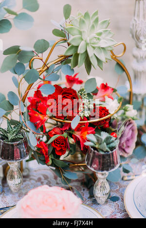 Bellissimo mazzo di nozze con molla rossa fiori sul tavolo vicino fino Foto Stock