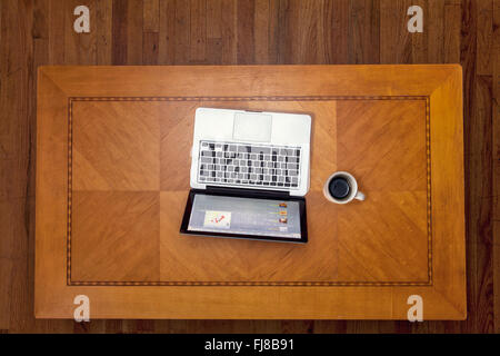 Guardando verso il basso su un art deco table top con un computer portatile ed una tazza di caffè. Foto Stock