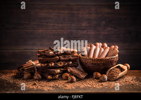 Diversi tipi di cioccolatini con dadi e cacao in polvere Foto Stock