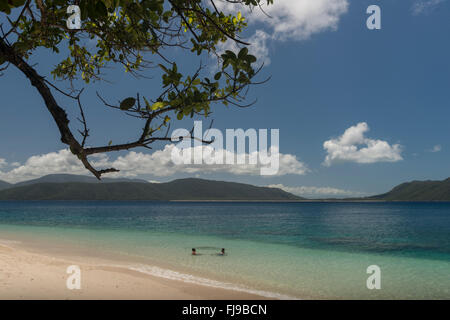 Bella bianca Nudey Beach con i turisti, snorkeling, vela passando, alcuni incredibili formazioni rocciose e le acque turchesi di Fitzroy Island e della terraferma di Cairns in background. Foto Stock