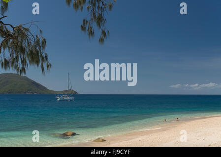 Bella bianca Nudey Beach con i turisti, snorkeling, vela passando, alcuni incredibili formazioni rocciose e le acque turchesi di Fitzroy Island e della terraferma di Cairns in background. Foto Stock