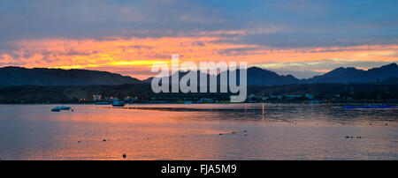 SHARM EL SHEIKH, Egitto - Marzo 1, 2014: Barche a motore ancorato tra la baia, tramonto, costa del mar rosso dalla spiaggia dell'hotel Foto Stock