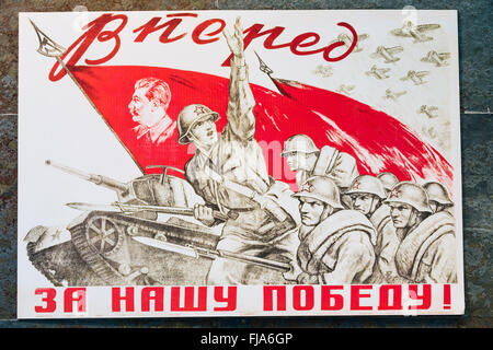 Russia sovietica patriottica poster di propaganda da guerra mondiale II con immagine del soldato andando su attacco con il fucile e bandiera Foto Stock