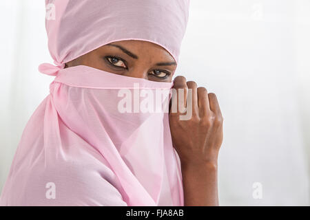 Bella africano nero donna musulmana che indossa velo rosa Foto Stock