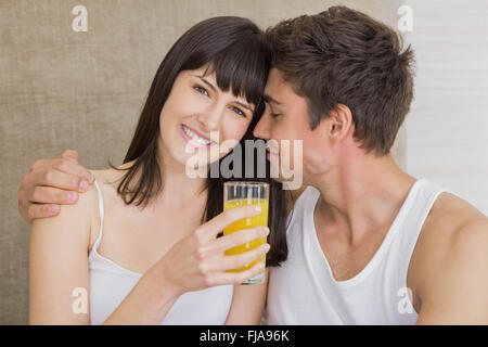 Donna di bere succo di frutta mentre l uomo abbracciando Foto Stock