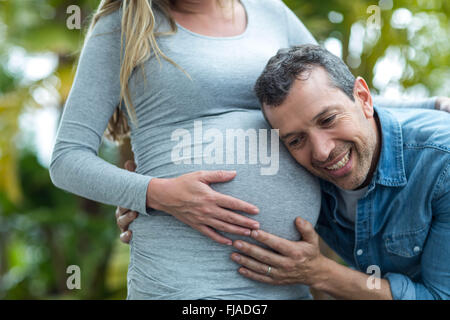 Uomo che ascolta a donne in stato di gravidanza womans stomaco Foto Stock