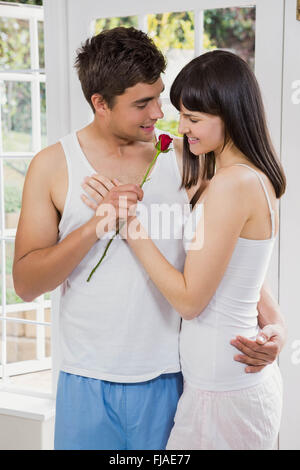 L'uomo che offre una rosa rossa per donna Foto Stock