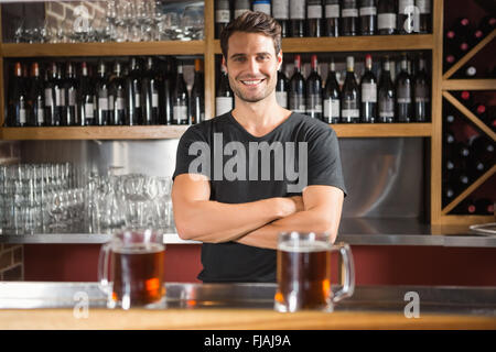 Bel bar gara in piedi dietro il suo contatore Foto Stock