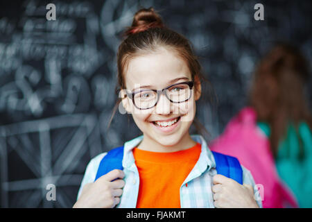 Felice bambina indossa occhiali guardando la fotocamera Foto Stock
